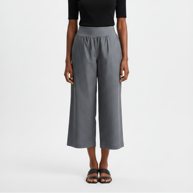 Woman wearing a black top and gray wide-leg pants on a white background