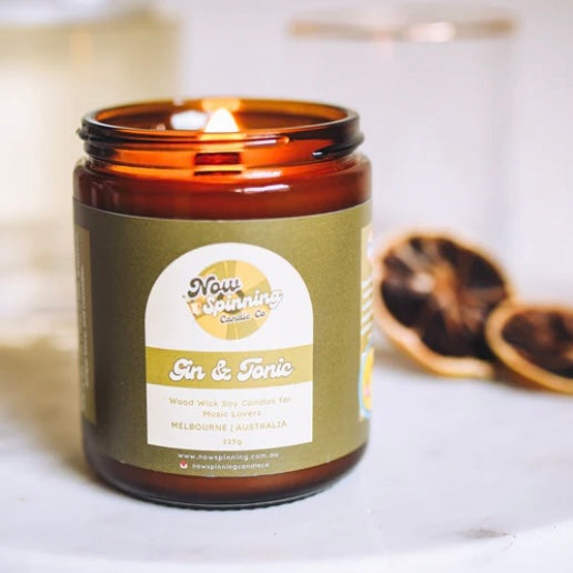 Candle in an amber jar with a label on a white surface