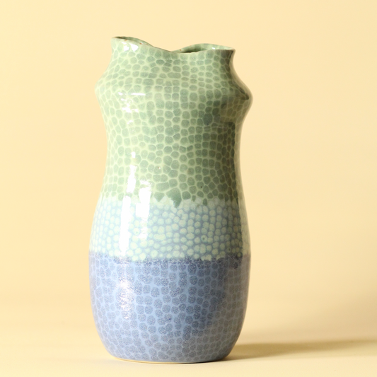 Ceramic vase with mosaic pattern on a beige background