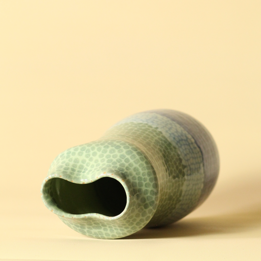 Textured green vase on a beige background