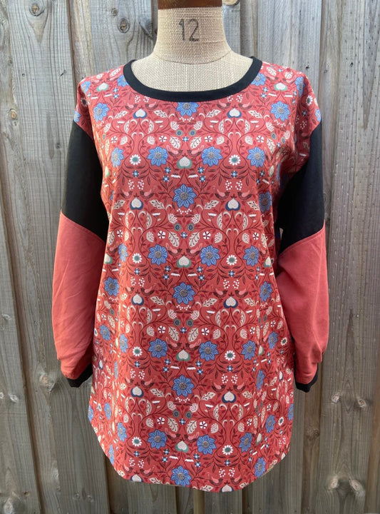 Floral patterned tunic top on a mannequin against a wooden background