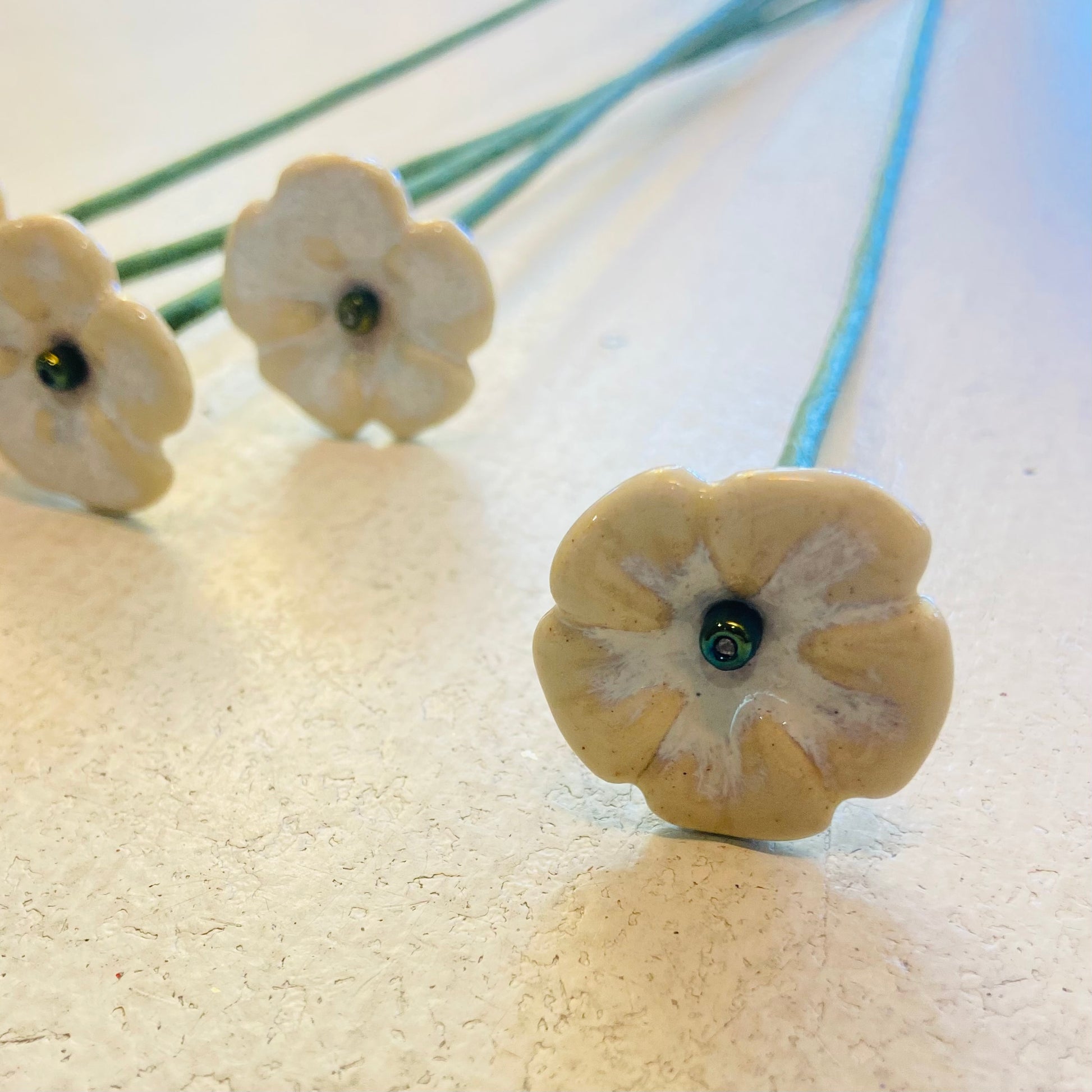 Close-up of ceramic flower-shaped beads on a textured surface