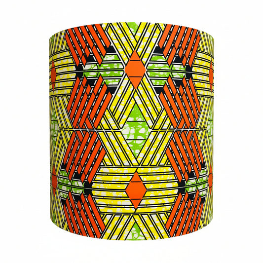 Geometric patterned lampshade on a stand against a neutral wall.