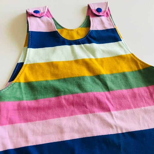 Colorful striped long romper detail with blue buttons on a white background