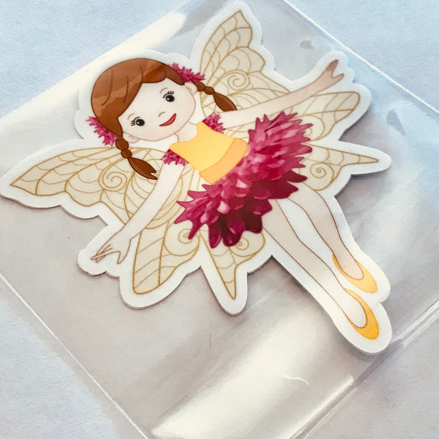 Sticker of a fairy with pink hair and a pink flower on a clear background