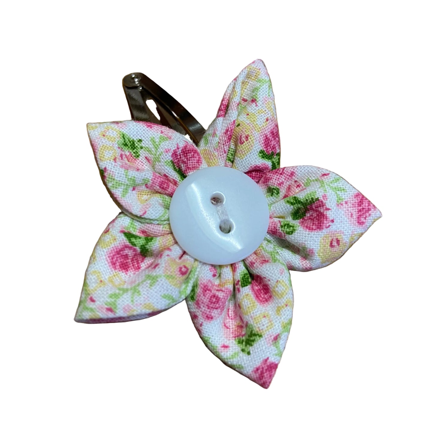 Floral fabric flower hair clip with a button center on a wooden surface