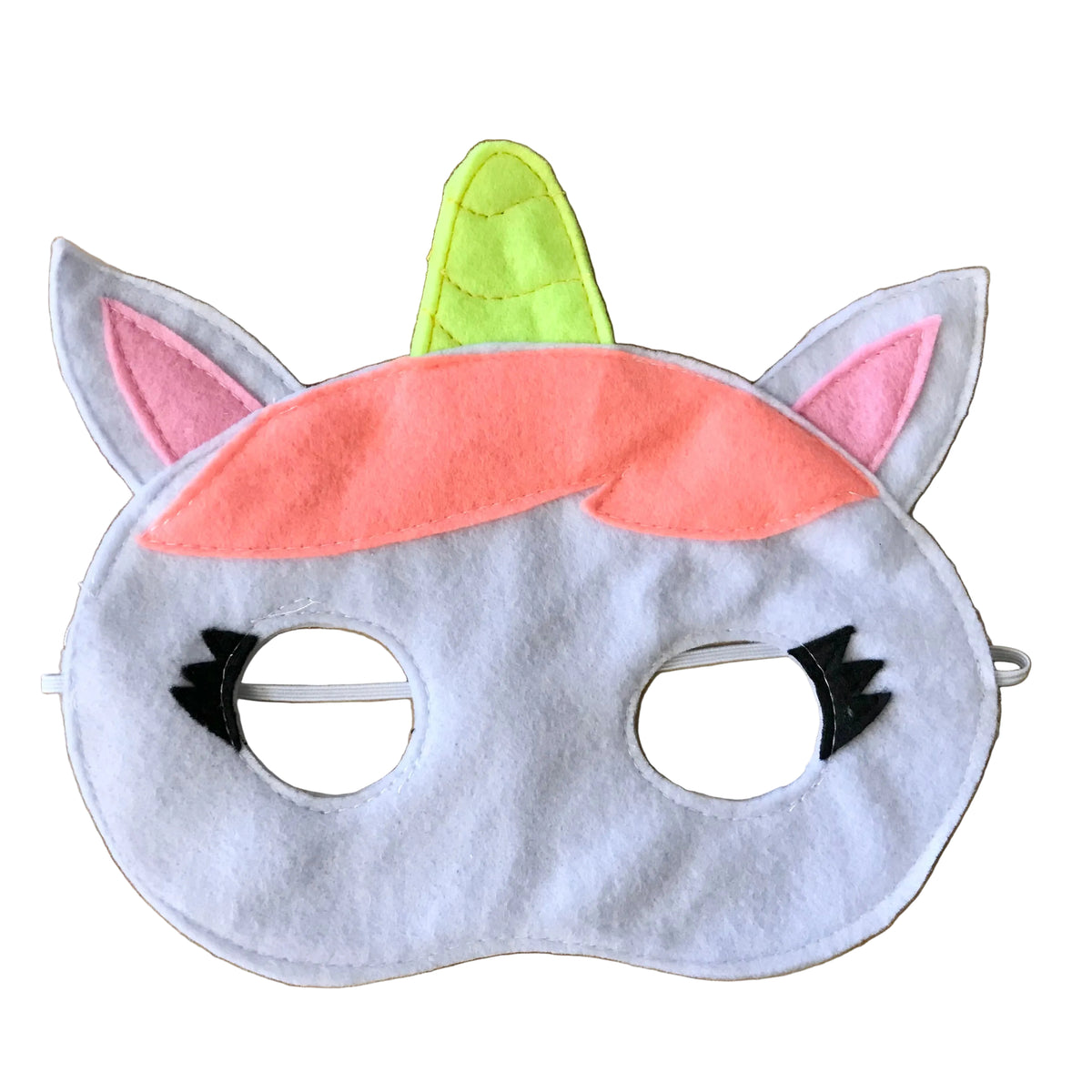 A handmade felt unicorn mask for kids, featuring a white face, pink inner ears, a bright yellow horn, a peach-pink mane, and black eyelashes, displayed on a light wood background.
