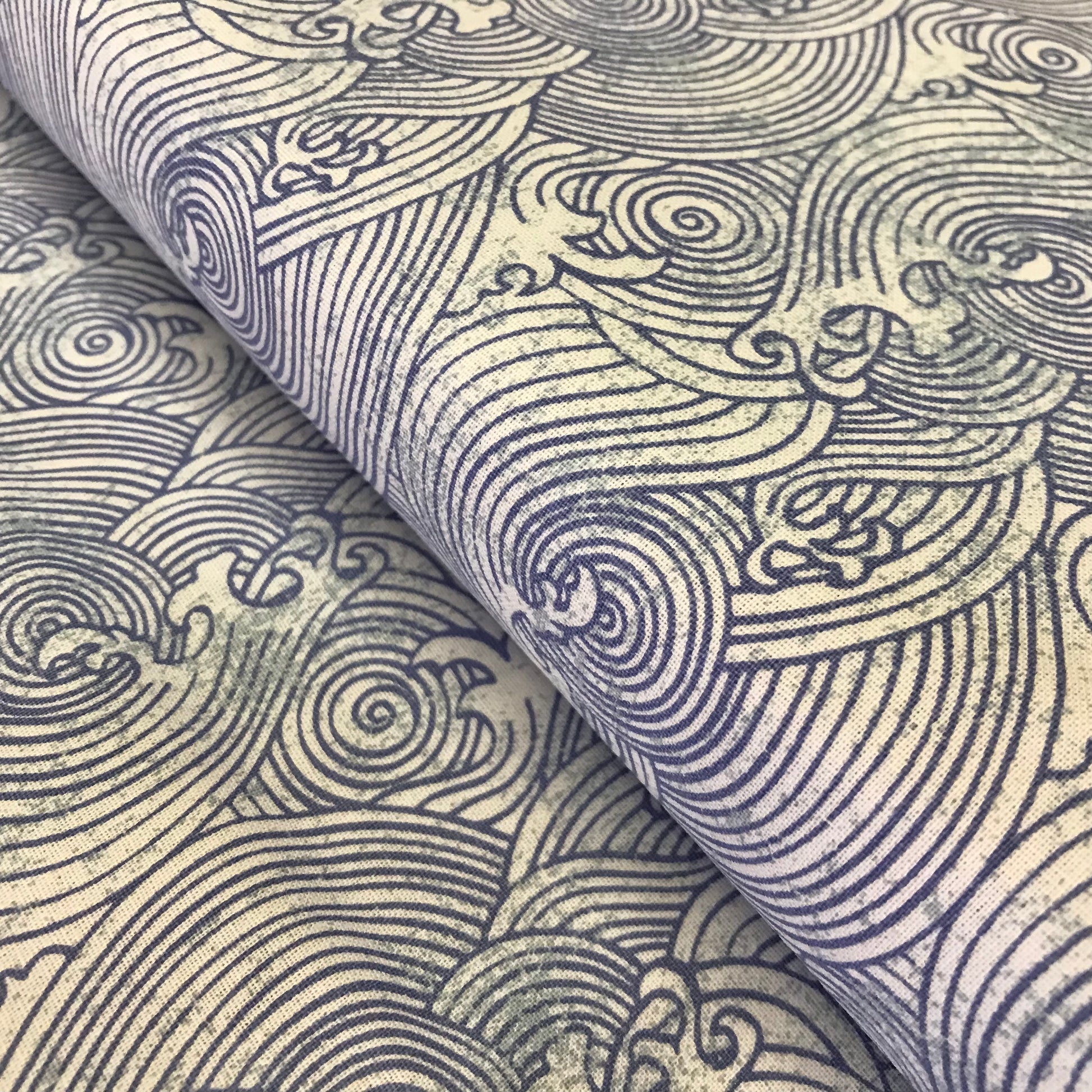 Textile with intricate wave pattern in blue on beige background