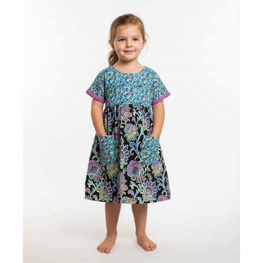 Young girl wearing a colorful floral dress on a white background
