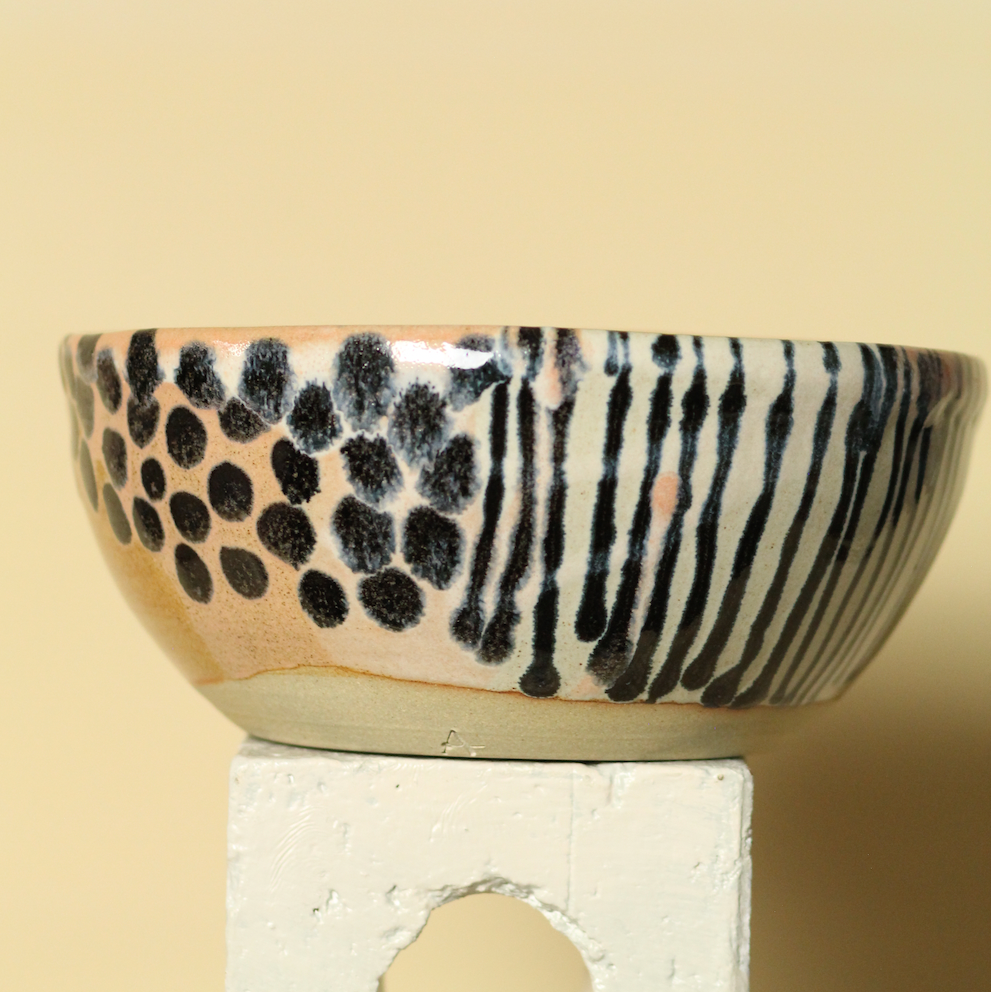 Ceramic bowl with black and white pattern on a beige background