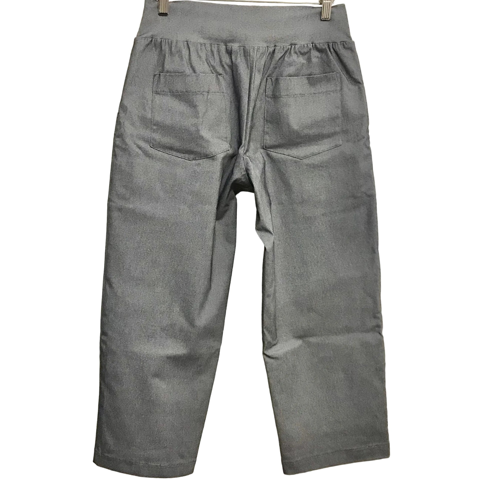Gray pants hanging on a rack against a plain background