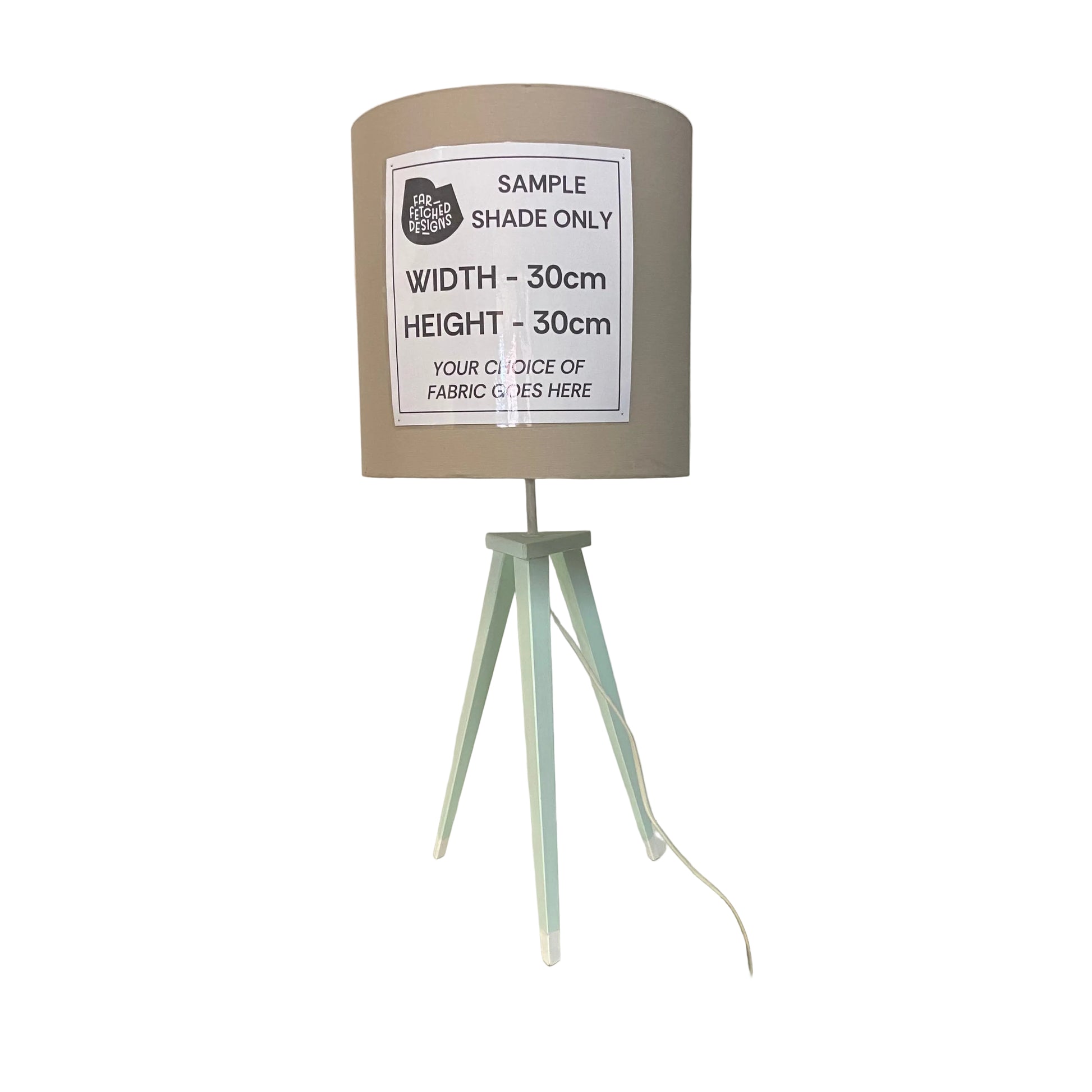 Lampshade on a stand with a label indicating dimensions and fabric choice options, in a store setting.