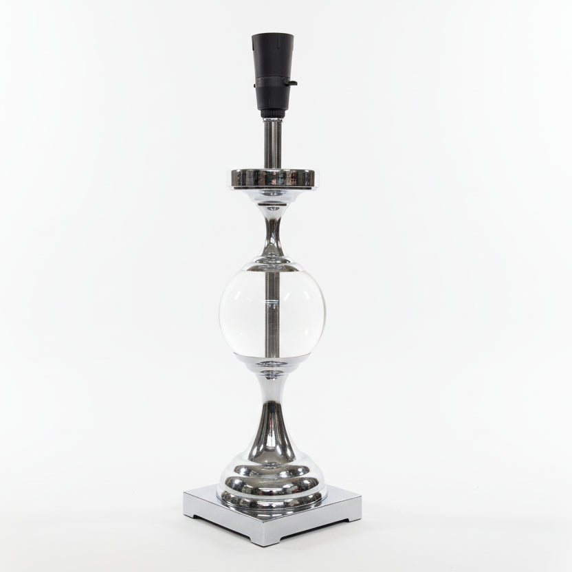 Decorative lamp with glass sphere and metallic base on a white surface.