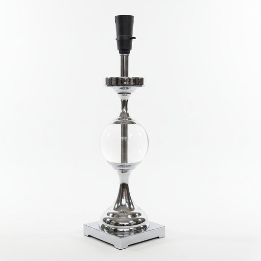 Decorative lamp with glass sphere and metallic base on a white surface.