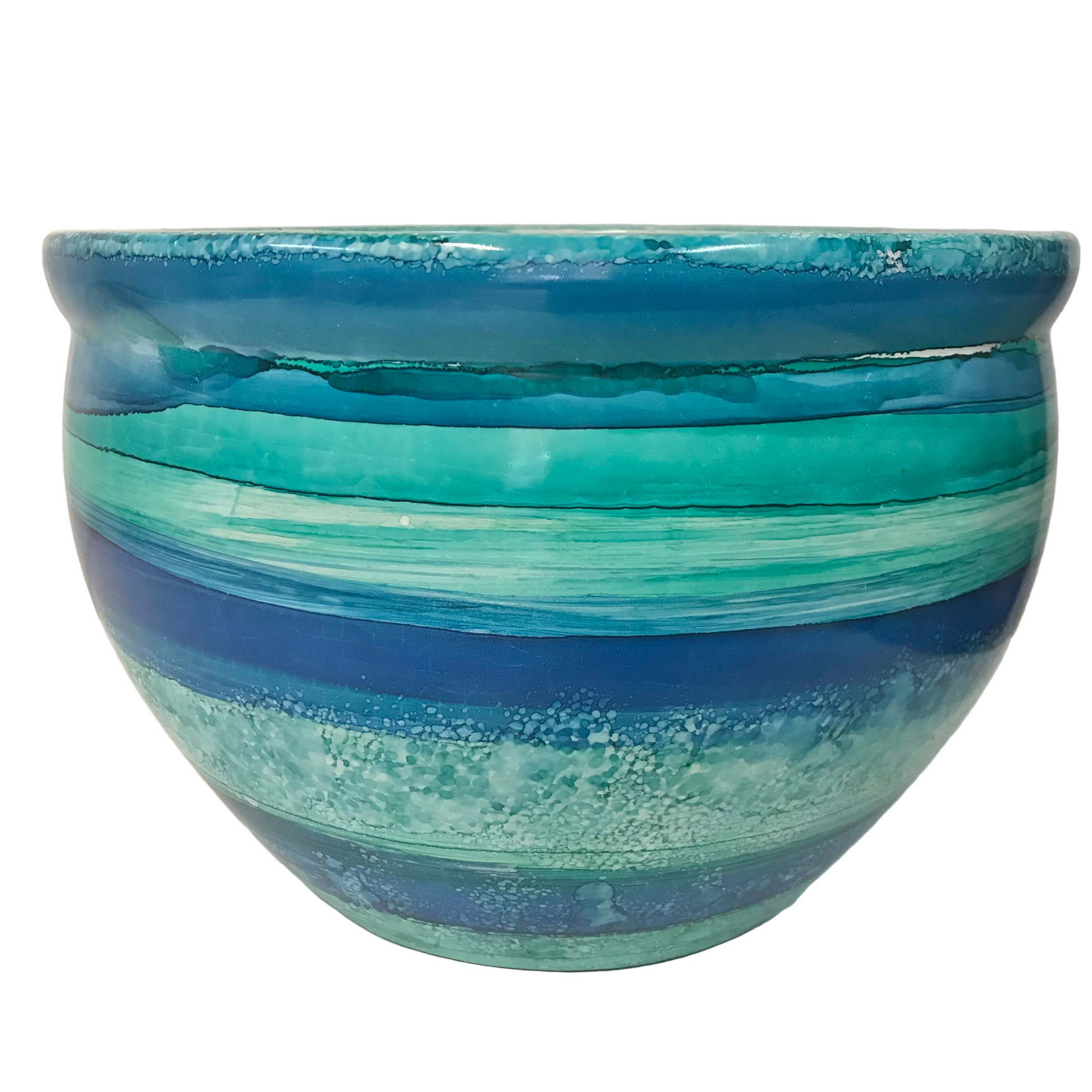Blue and green striped ceramic planter on a white background