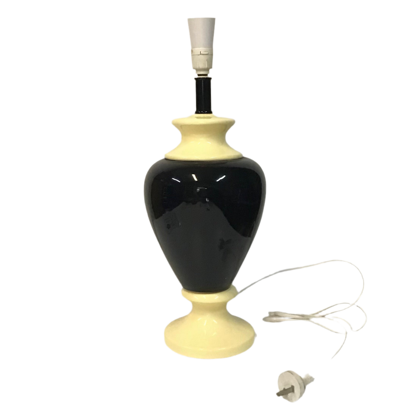Black and beige table lamp with visible power cord on a white background