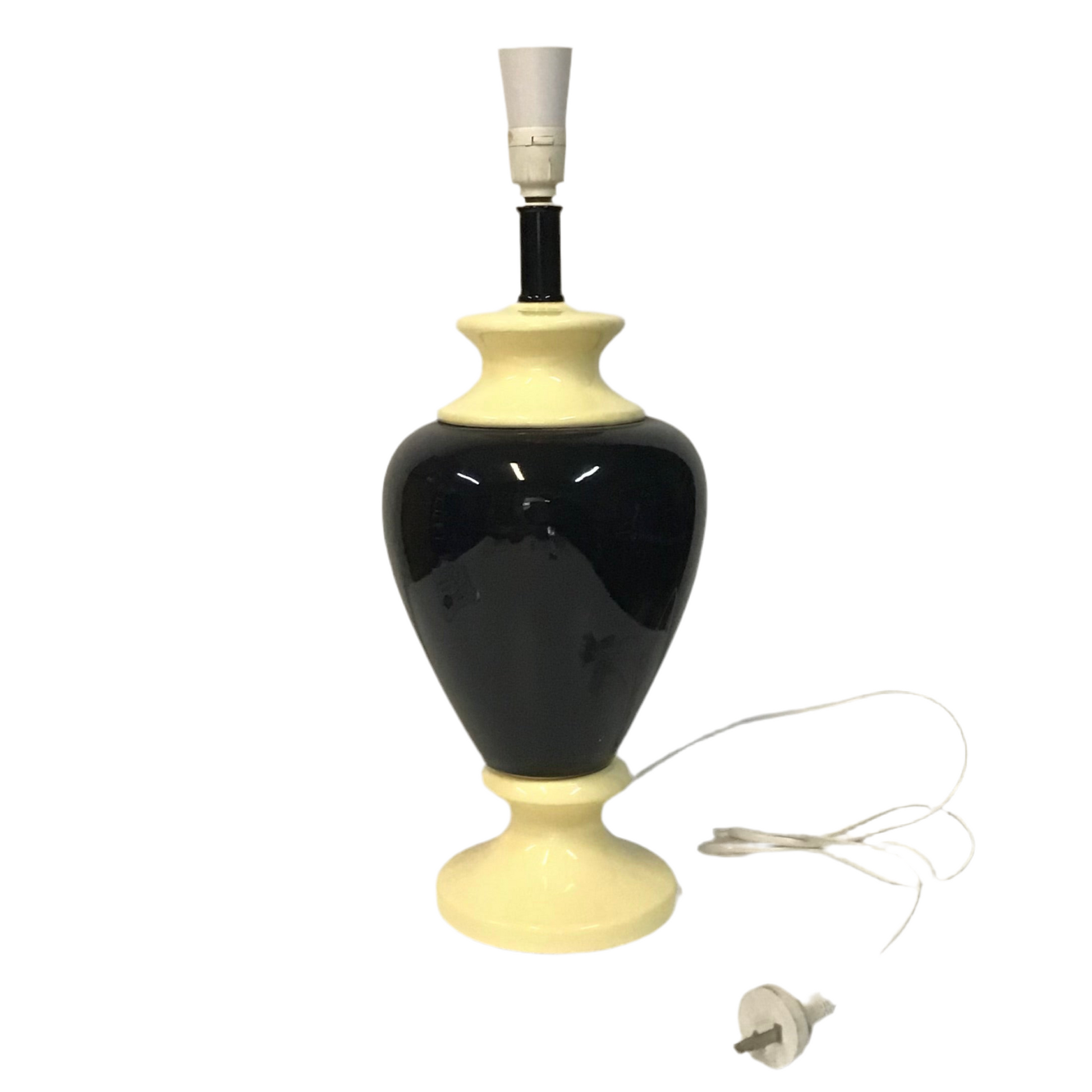 Black and beige table lamp with visible power cord on a white background