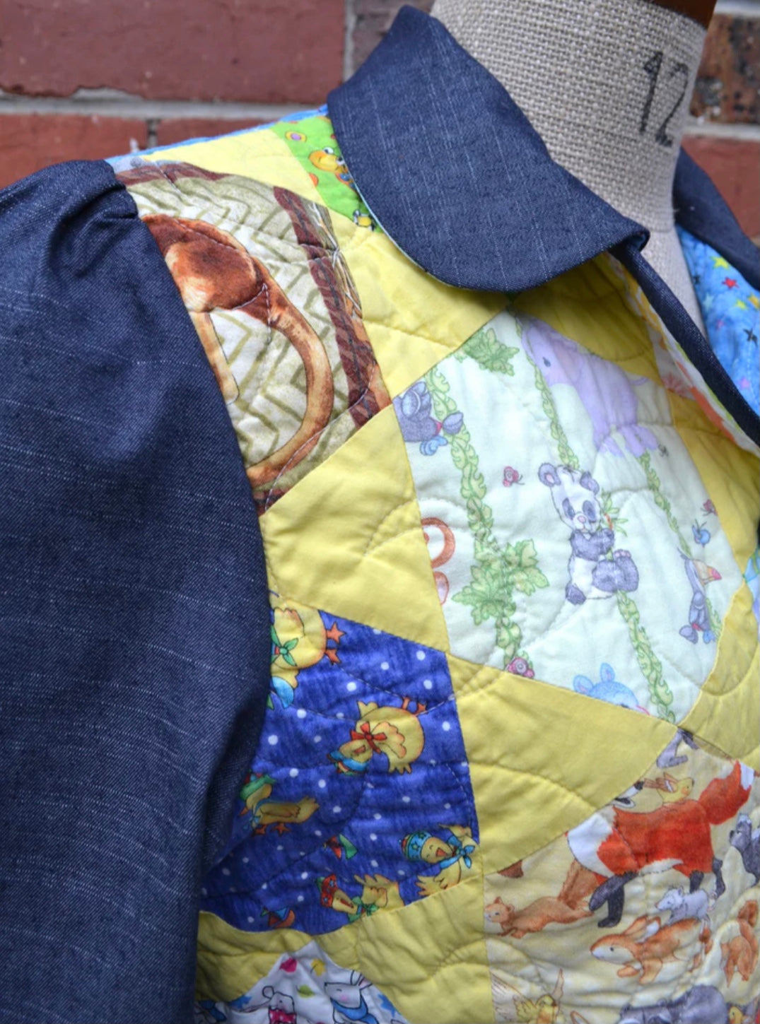 Colorful quilted jacket with cartoon characters and a denim blue collar and sleeves