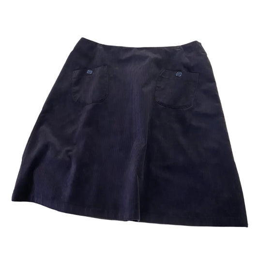 Navy blue cord skirt on a white table with various items around