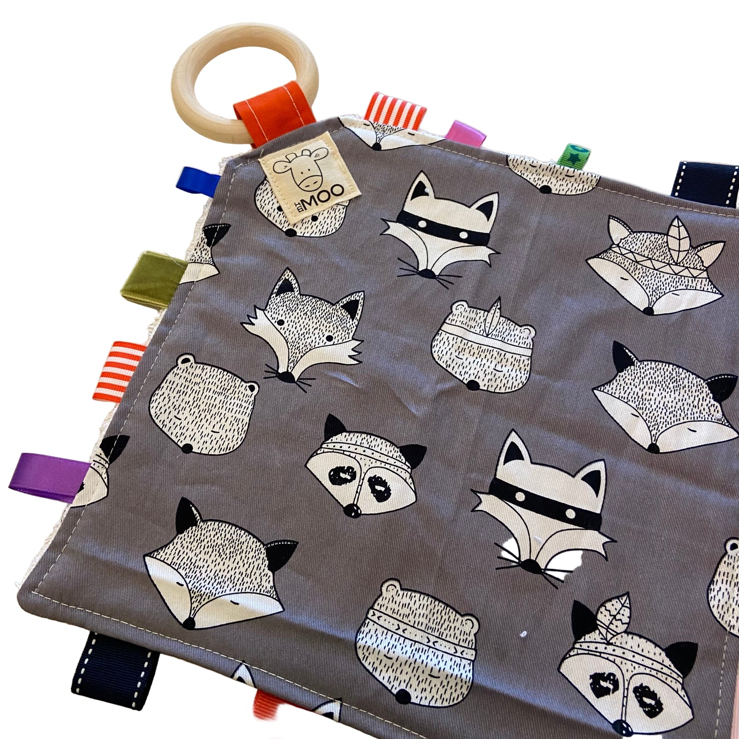Fabric taggy toy with fox and raccoon patterns on a gray background