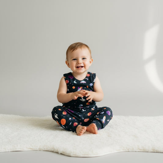 Children's overalls with space-themed print on a white background