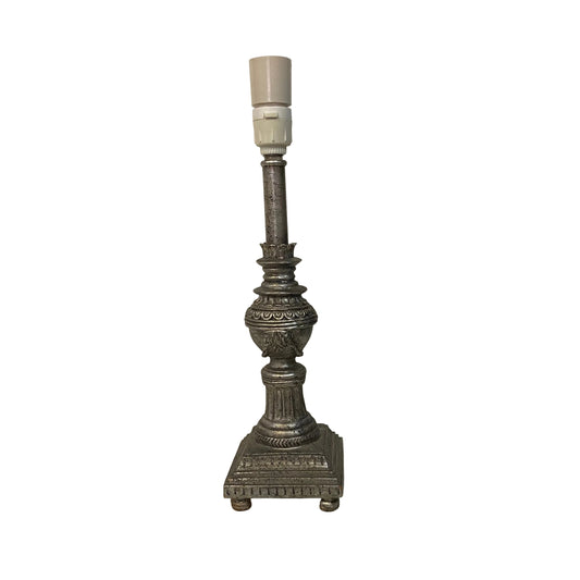 Decorative candlestick lamp on a white surface with a plain background