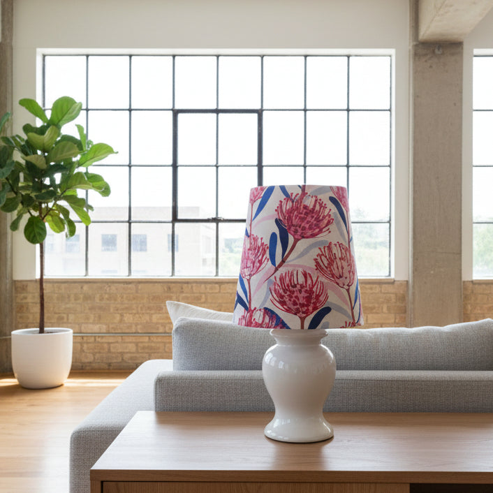 Decorative lamp with a colorful floral shade on a wooden table in a living room.