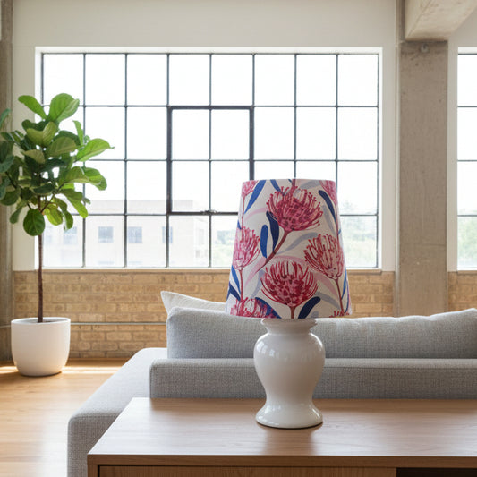 Decorative lamp with a colorful floral shade on a wooden table in a living room.