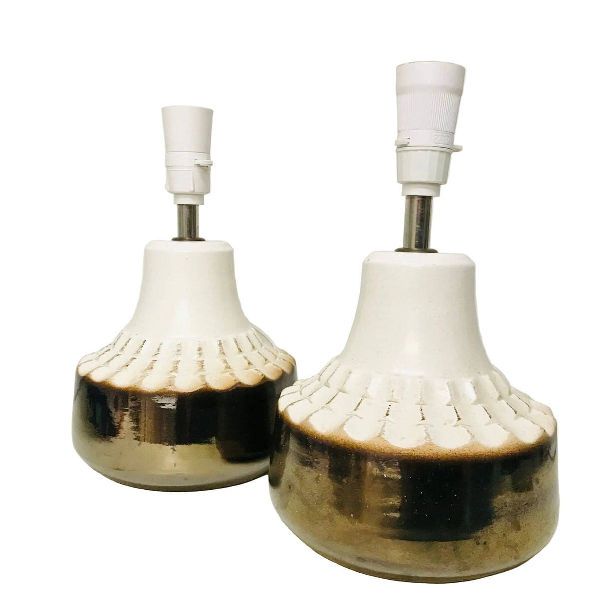 Two vintage ceramic table lamps with white ceramic shades, scalloped textured bands, and dark brown to gold glazed bases, shown against a plain off-white background.