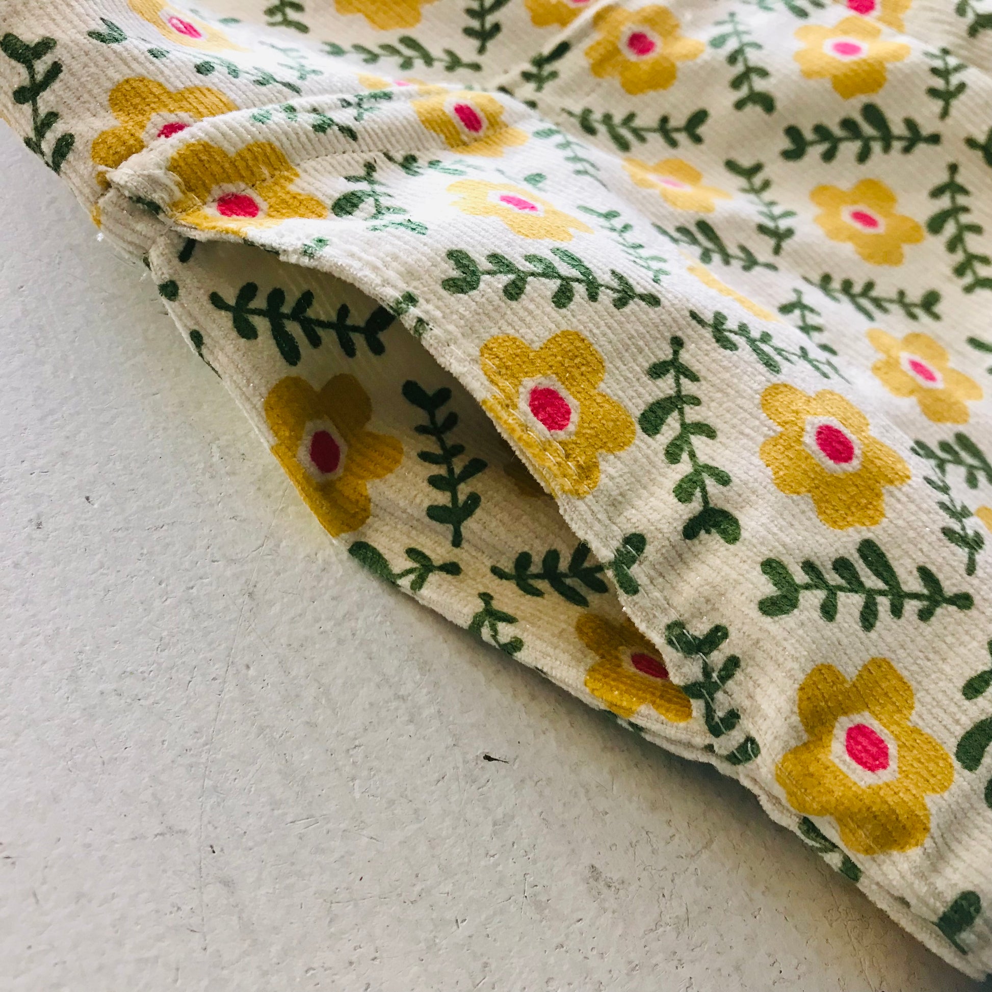 kids overalls with tie shoulders and yellow flower print, made of pinwale cord