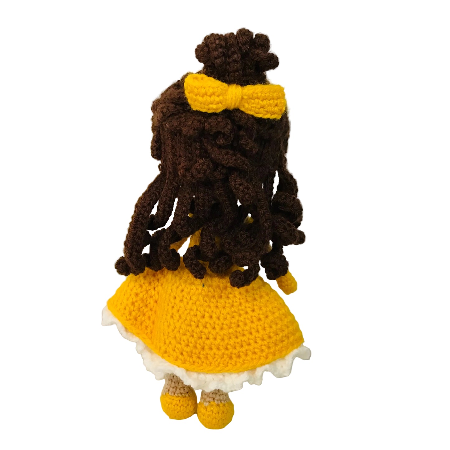 Crocheted doll with yellow dress and bow on a white background