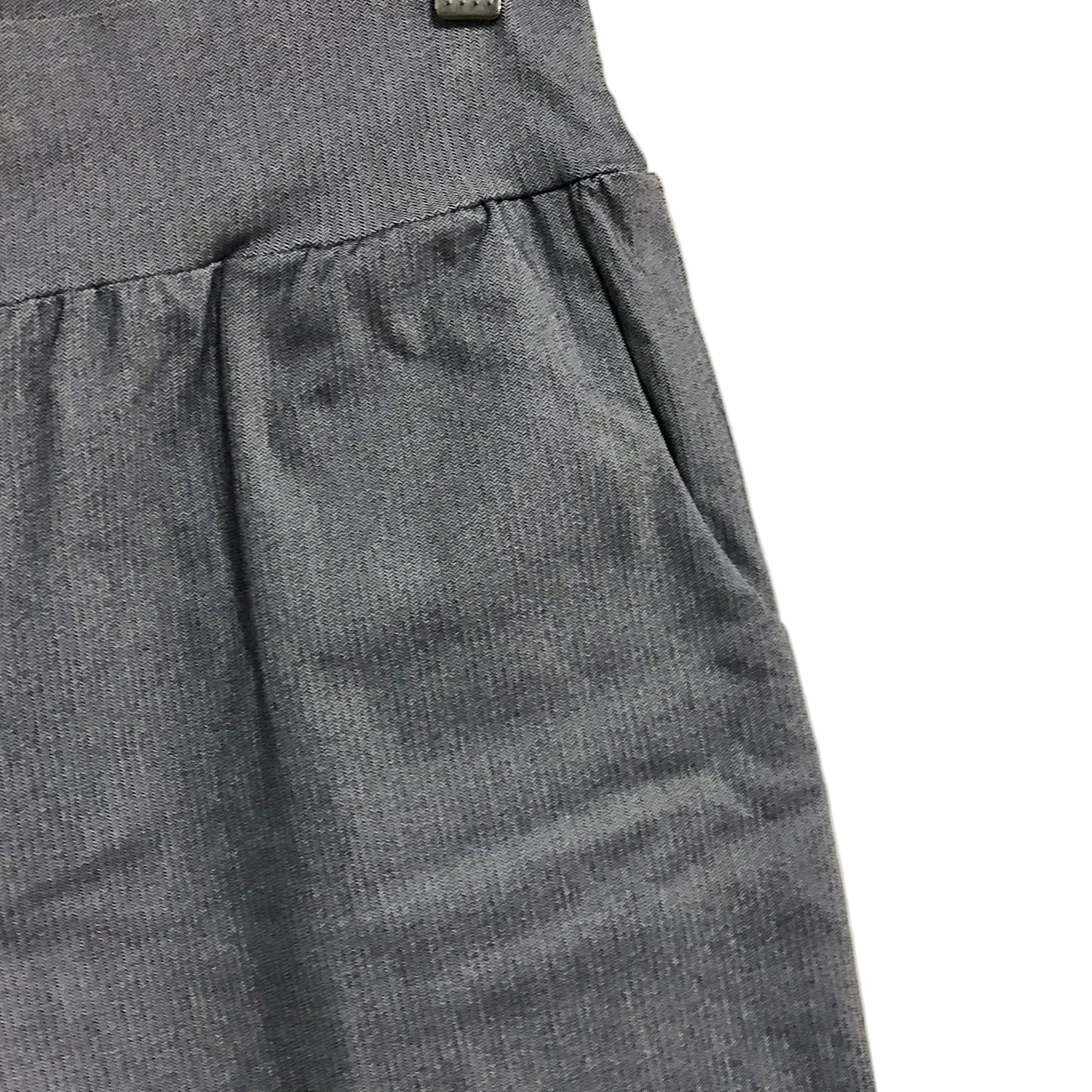 Close-up of gray pants with a beige background