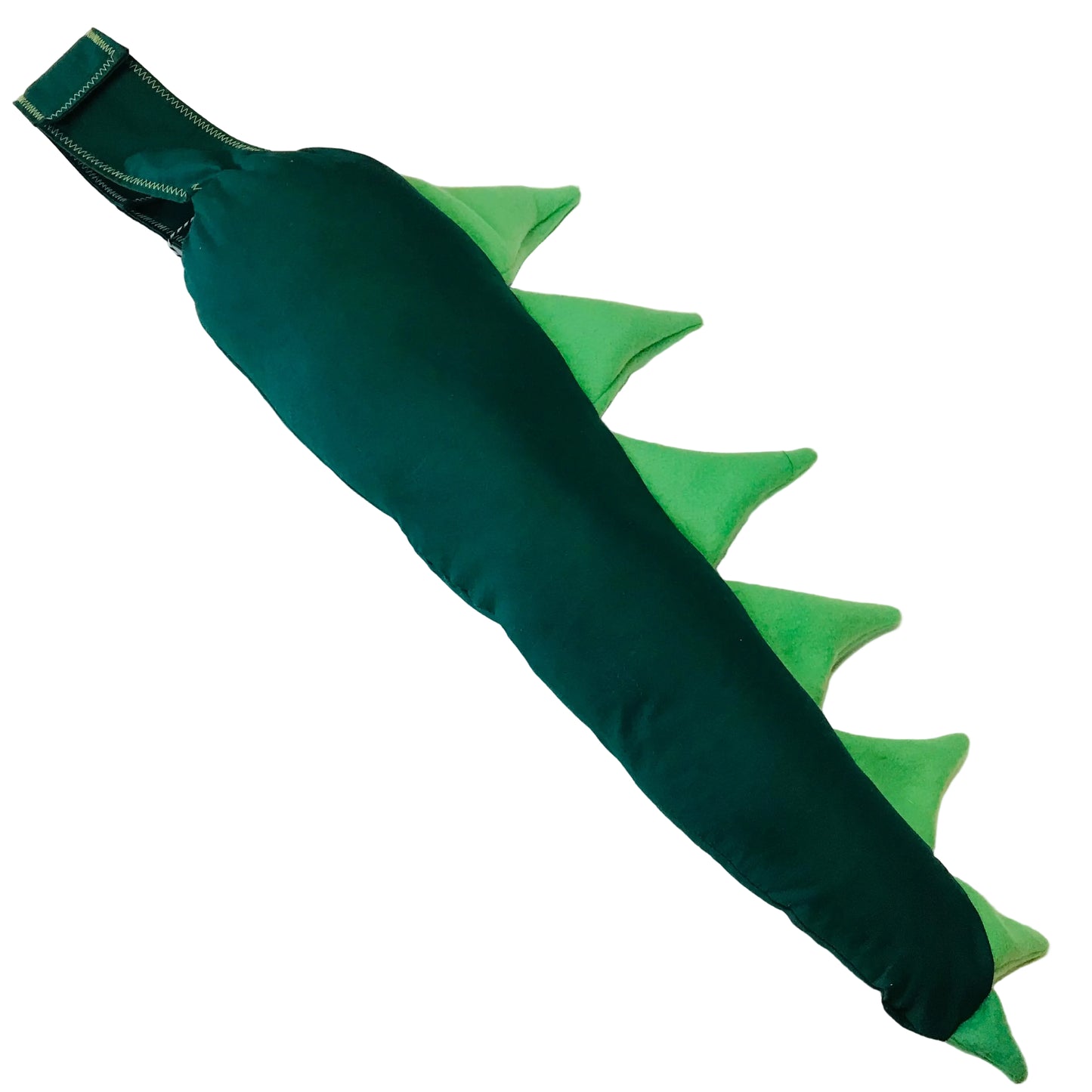 Green dinosaur tail pillow on a white surface