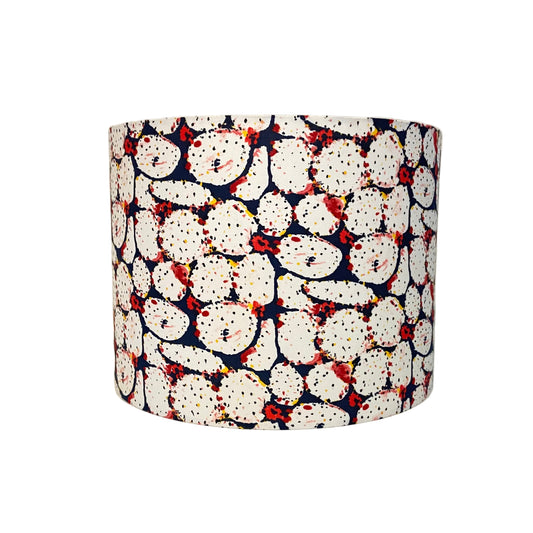 Cylindrical lampshade with a pattern of white shapes on a blue background