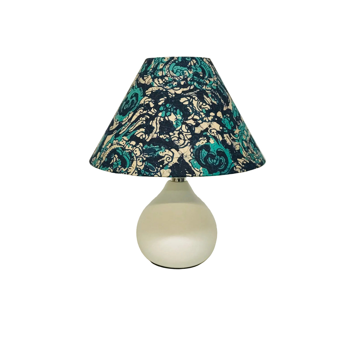A table lamp with a white rounded glass base and a conical fabric shade featuring a dark navy and teal floral damask pattern on a cream background.