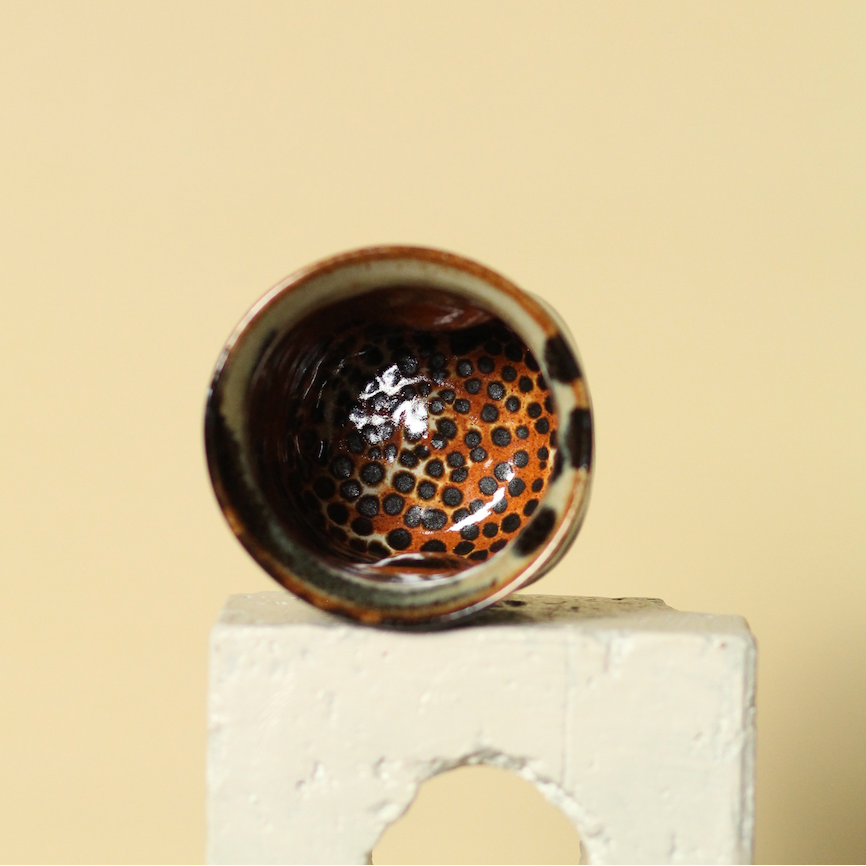 Ceramic cup with textured interior on a beige background