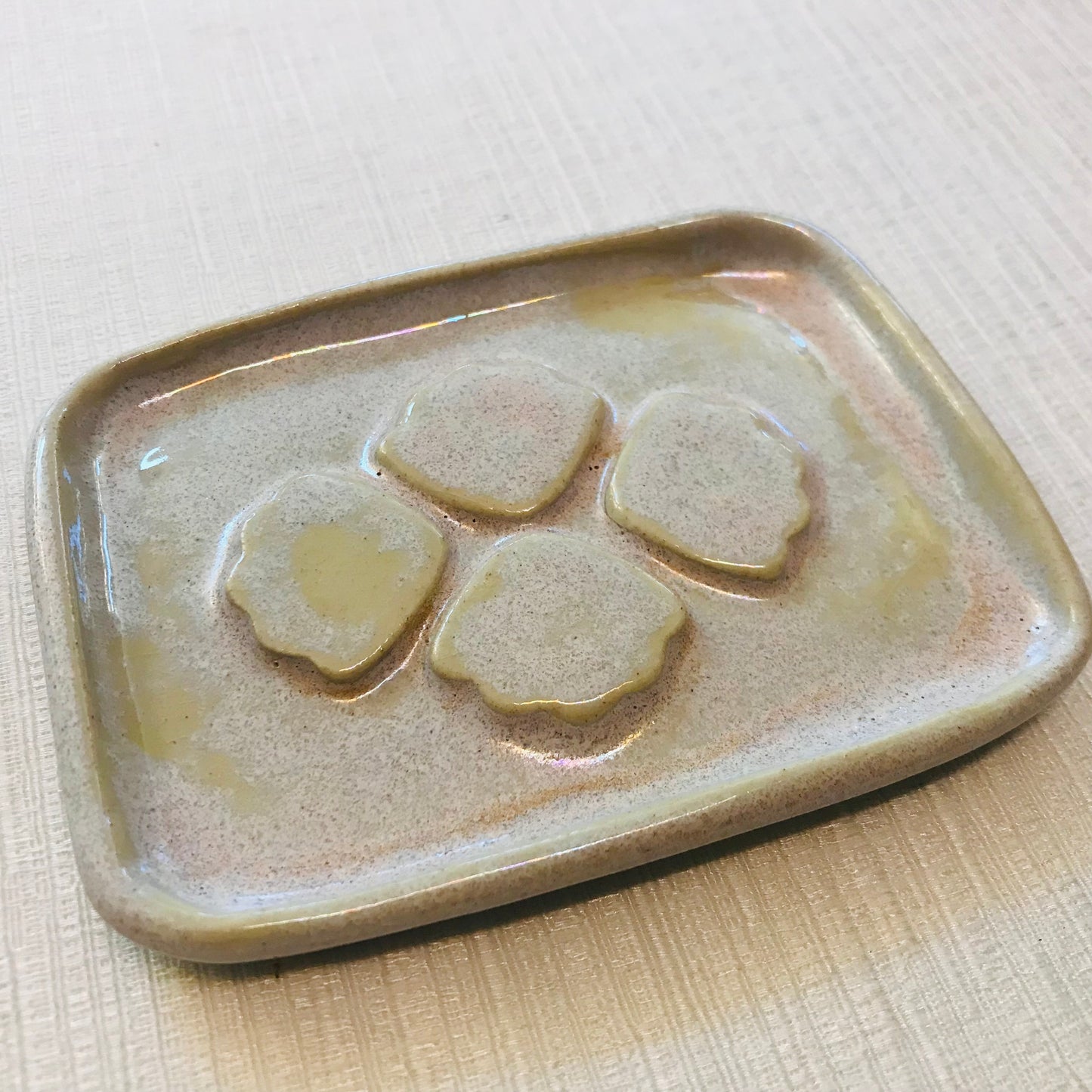 Ceramic soap dish on a beige surface