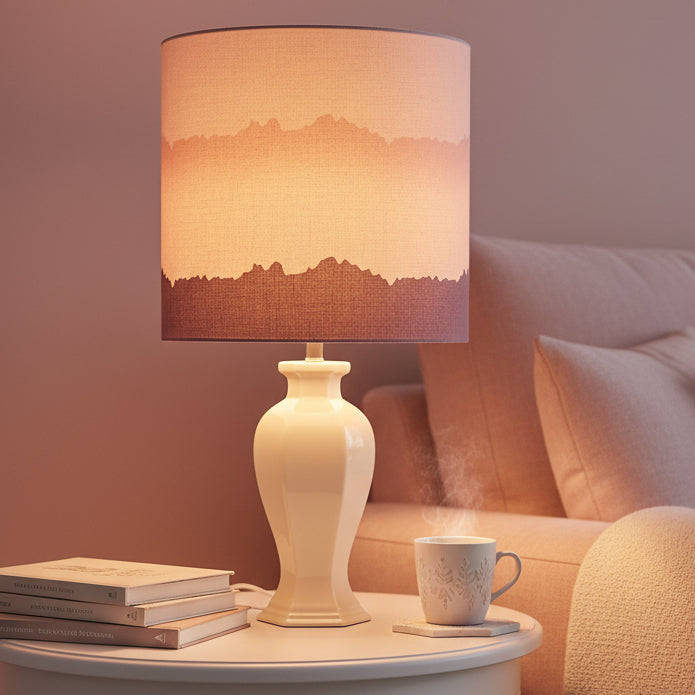 Lamp with a pink and purple gradient shade on a white surface.