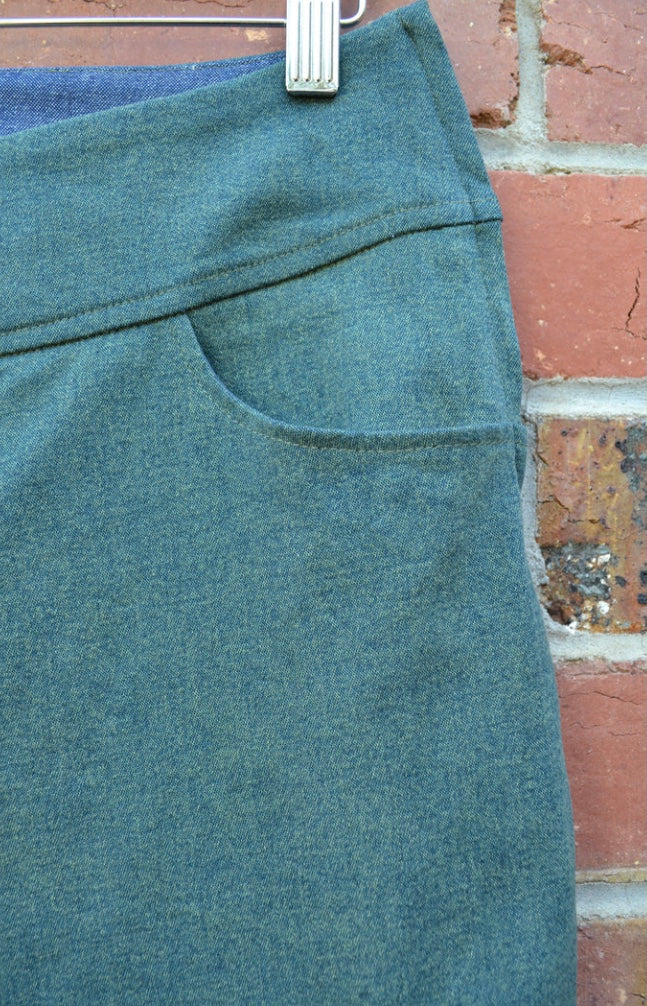 Green fabric on a hanger against a brick wall