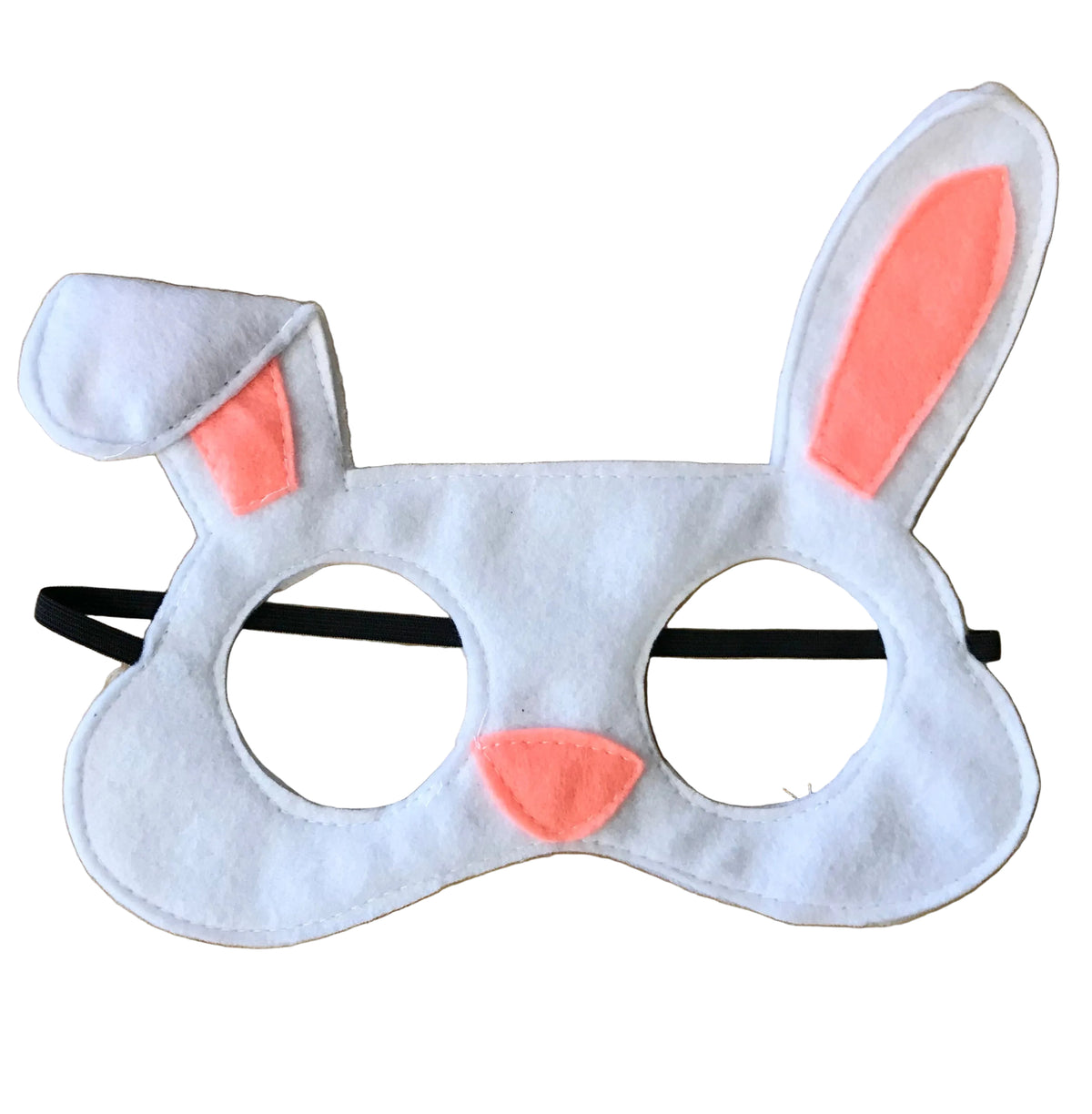 A white felt bunny mask with pink inner ears and a pink nose, attached to a black elastic band, displayed on a light wood background.
