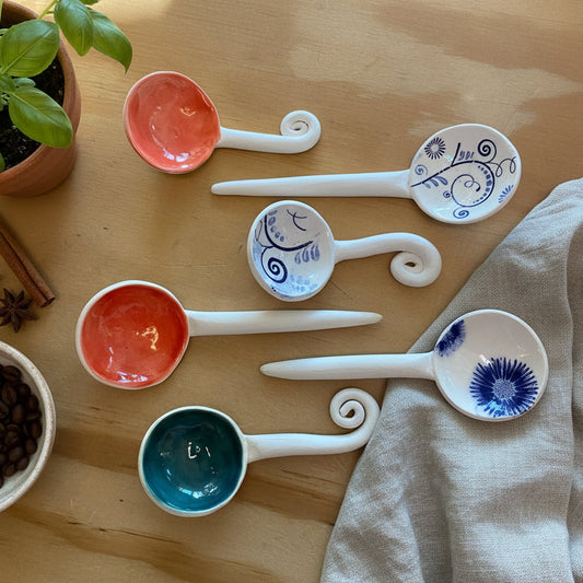 Set of ceramic spoons with decorative handles on a wooden surface