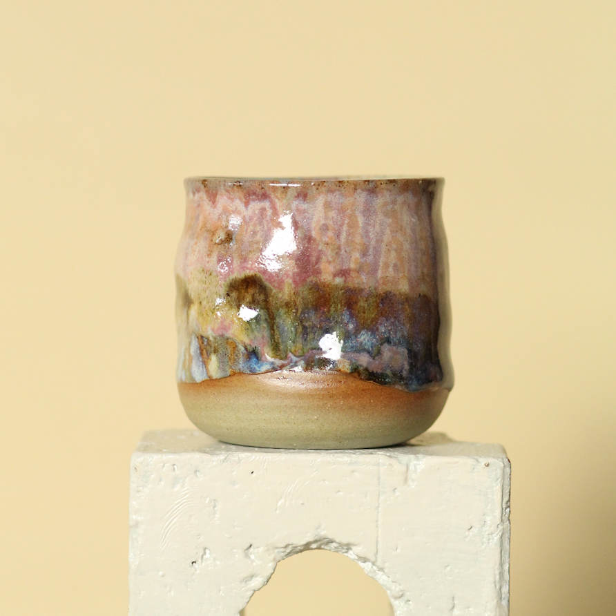 Ceramic tumbler with a textured surface on a light beige background
