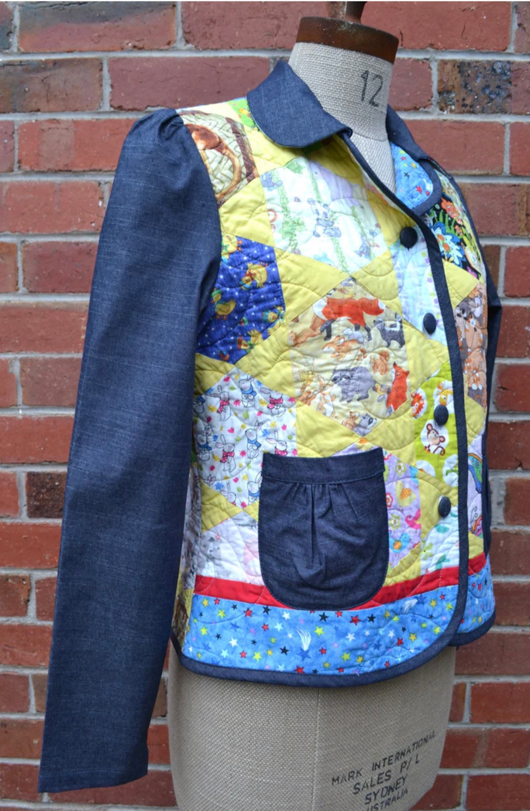 Colorful quilted jacket on a mannequin against a brick wall