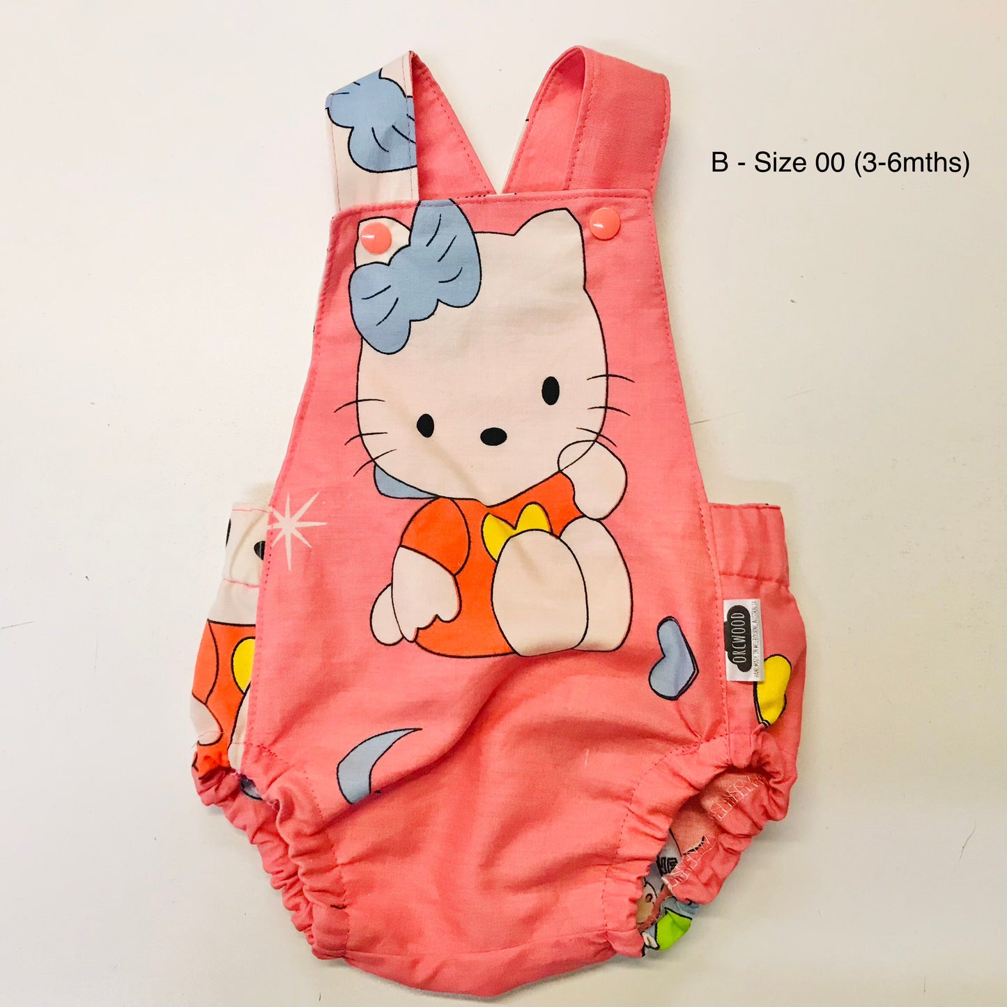 Pink baby romper with cartoon design on a white background