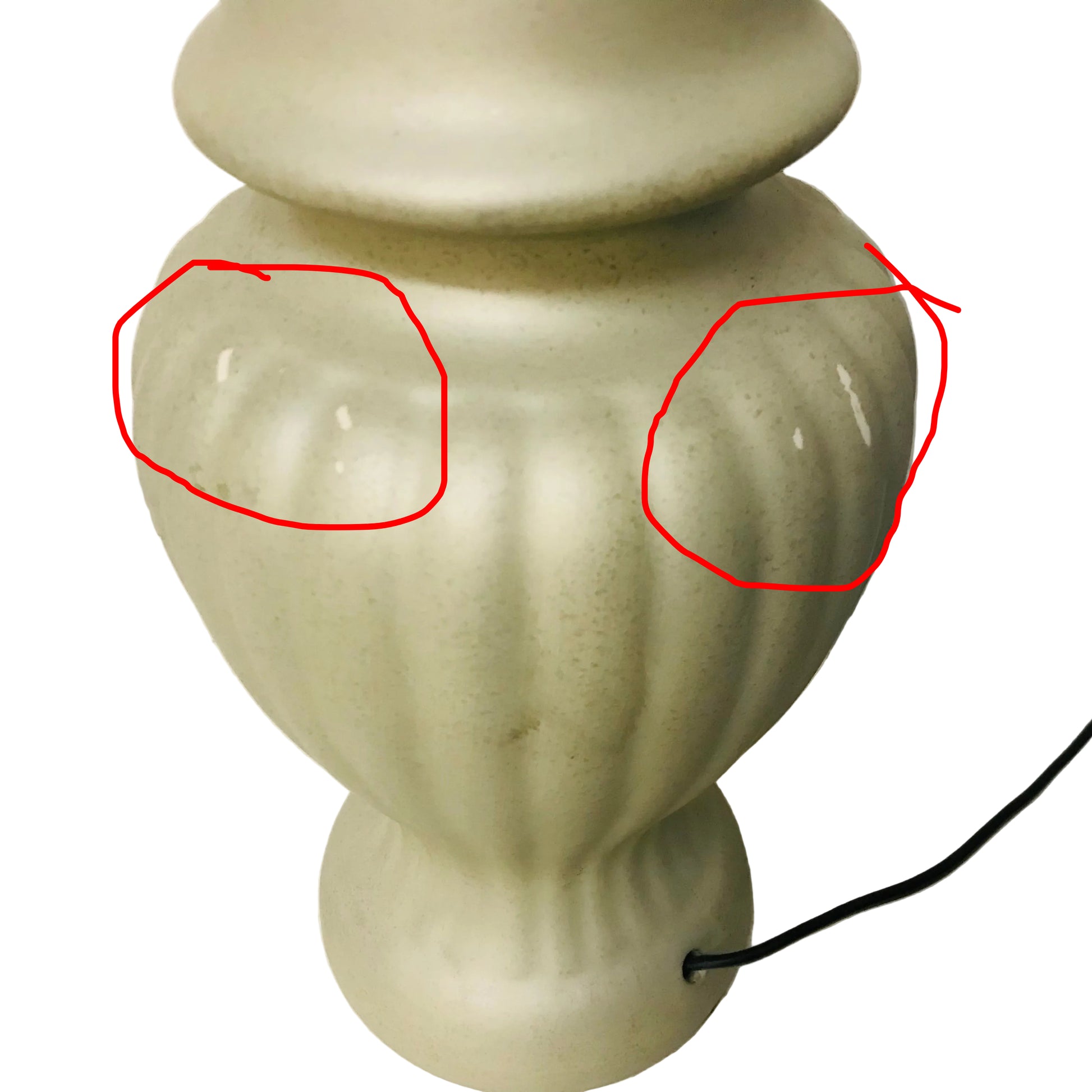 Beige ceramic urn-shaped lamp on a white surface with a neutral background