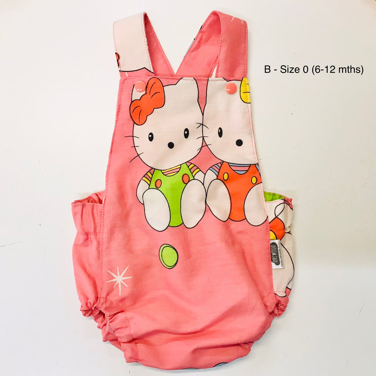 Pink baby romper with cartoon characters on a white background