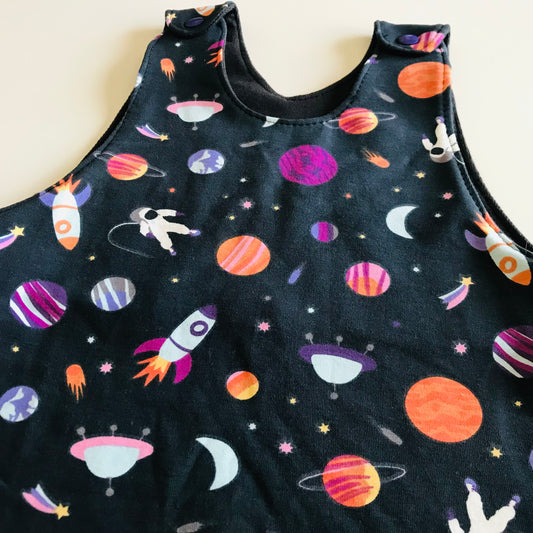 Children's romper with space-themed print on a plain background