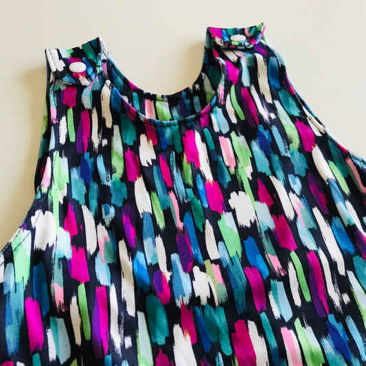 Colorful sleeveless baby romper with abstract pattern on a plain background