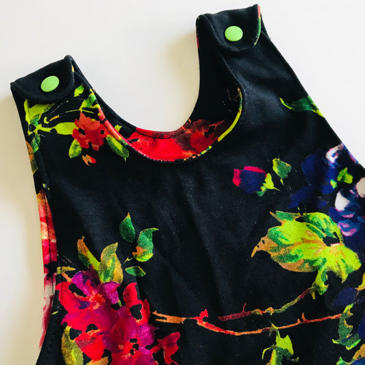 Black sleeveless baby romper with colorful floral patterns on a white background