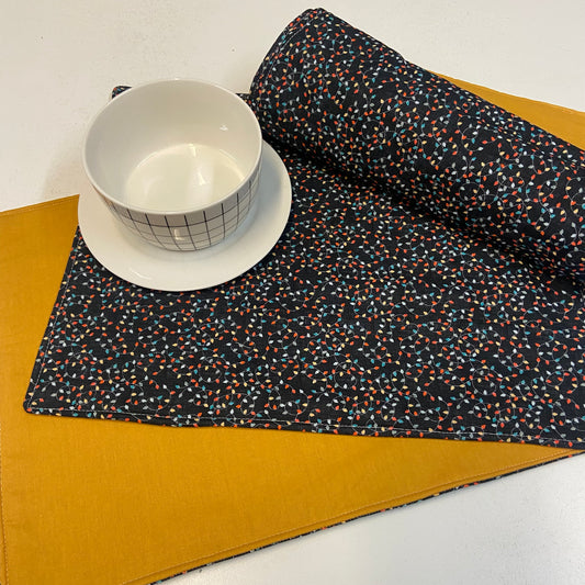 christmas  placemat with a white bowl and saucer on a yellow surface